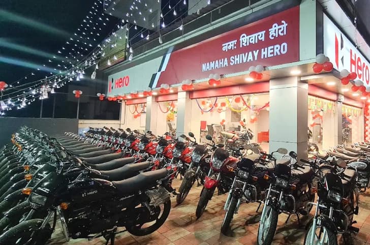 Hero showroom at night lit up with lights and Splendor bikes parked outside