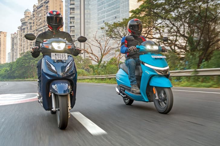Honda Activa and TVS Jupiter head on front tracking shot on road