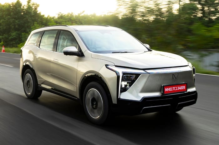 Mahindra XEV 9e desert myst (silver-gold colour) front right side action on road