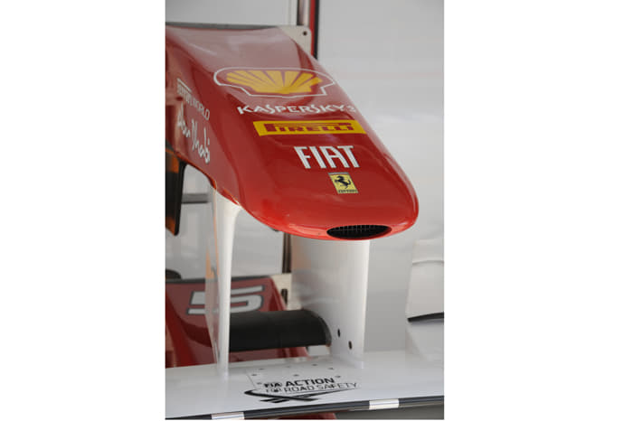 The nose section of Fernando Alonso’s Ferrari rests in the pit garage.
