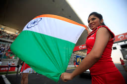 Grid girls hold the Indian flag.