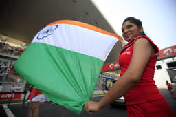 Grid girls hold the Indian flag.