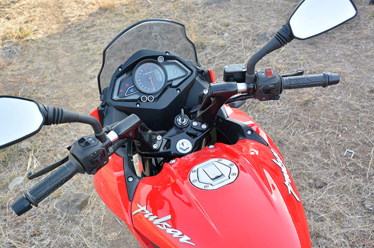 The Bajaj gets bar-mounted mirrors and a hinged fuel-cap.