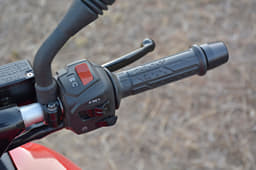 Grips on the Bajaj are soft to touch and heavy bar end weights are provided too. Switchgear illuminated blue here.