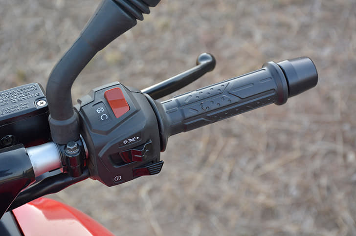 Grips on the Bajaj are soft to touch and heavy bar end weights are provided too. Switchgear illuminated blue here.