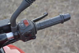 Grips on the Bajaj are soft to touch and heavy bar end weights are provided too. Switchgear illuminated blue here.