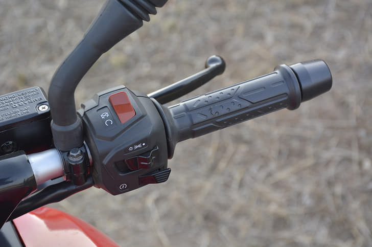Grips on the Bajaj are soft to touch and heavy bar end weights are provided too. Switchgear illuminated blue here.