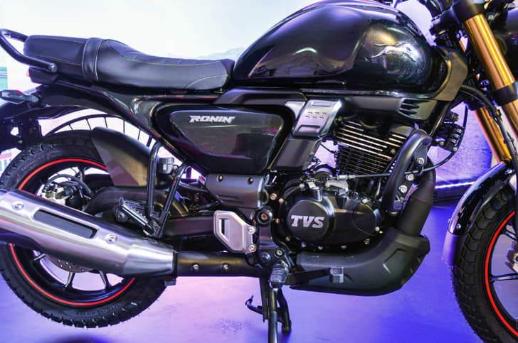 The large, rounded fuel-tank features subtle knee recesses, and the seat is a single-piece design.