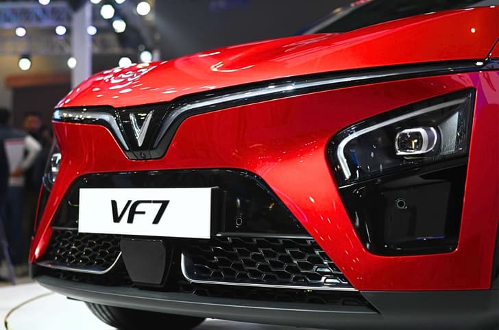 The signature 'V' motif design confirms it is a Vinfast car. Its bumper ahead houses parking sensors, LED headlights, and a front camera.
