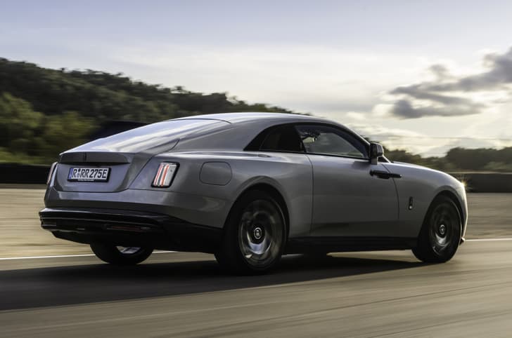 rolls royce spectre black badge in motion on road