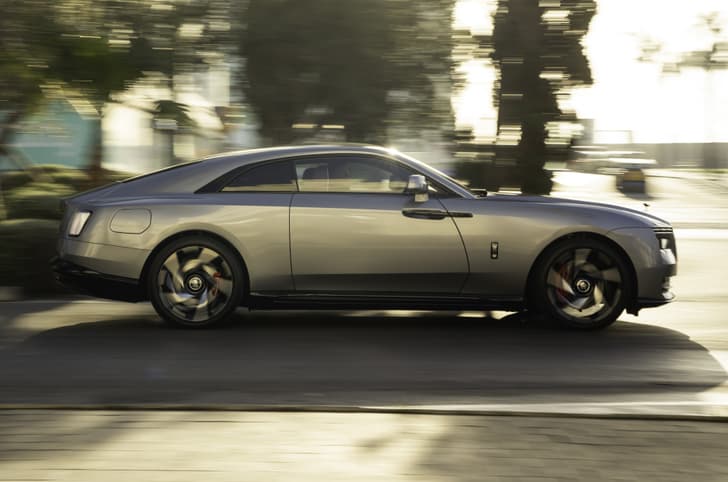 rolls royce spectre black badge side profile in motion on road