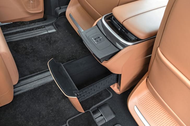 Front center console houses a massive storage compartment and 150W charging port.