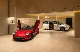 red MG cyberster and white M9 in the MG select showroom