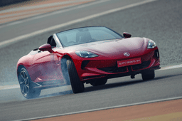MG Cyberster EV in red performing a high-speed drift on racetrack