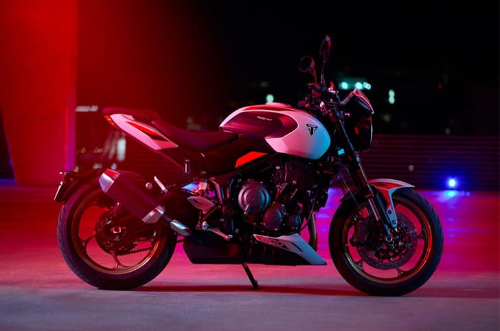 Triumph Trident 800 Ash Grey at night under red light shot.